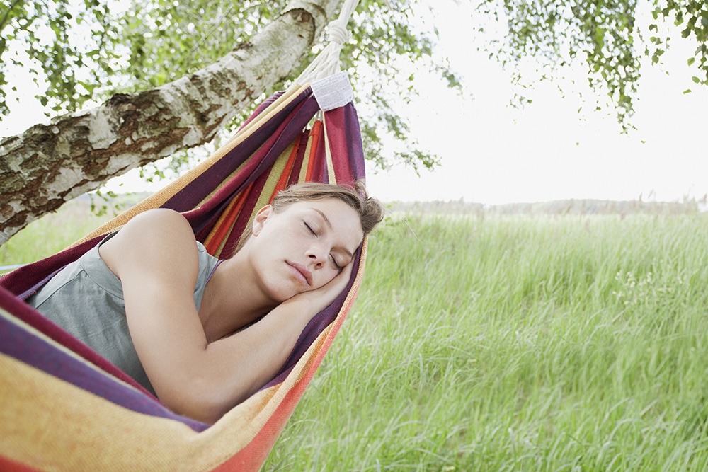 Young woman sleeping in hammock.